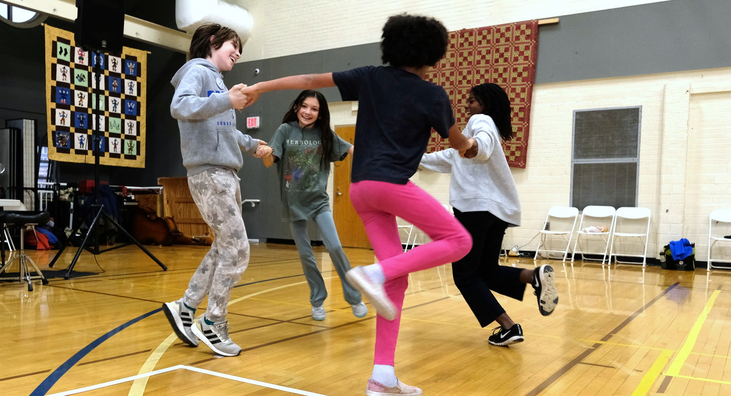 Children on a gym floor dancing in a circle